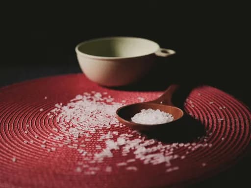 Cartoon bowl of rice with individual smiling and frowning grains peeking out in a chaotic, cutesy scene