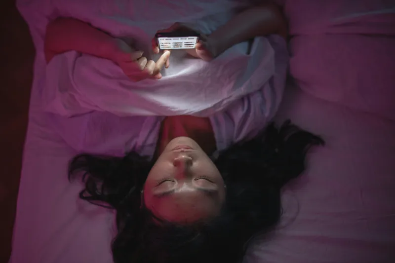 Picture of teen scrolling social media in bed at night